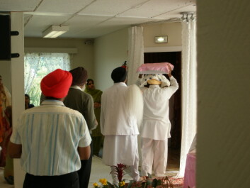 "Den hellige boken Guru Granth Sahib, som behandles som en levende guru, bæres til sitt sengeleie." "Den hellige boken Guru Granth Sahib, som behandles som en levende guru, bæres til sitt sengeleie."