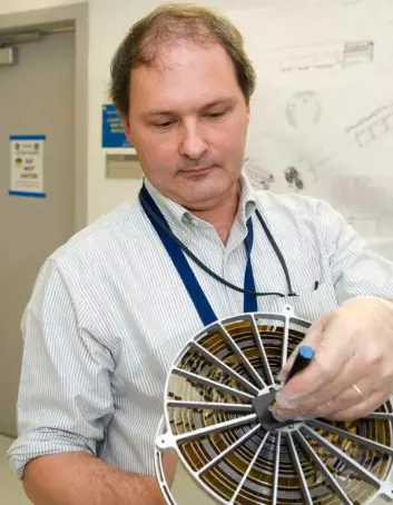 Sjefsforsker Keith Gendreau med et røntgenspeil som ligner ett av de 56 på NICER/SEXTANT. De konsentriske ringene fungerer som røntgenspeil, med svært slak vinkel mot retningen fra strålene. (Foto: Bill Hrybyk)