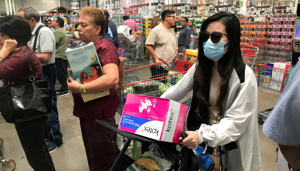 A woman wears a protective mask as she and others wait to pay at a supermarket during an outbreak of the coronavirus (COVID-19) in Mexico City, Mexico March 13, 2020.