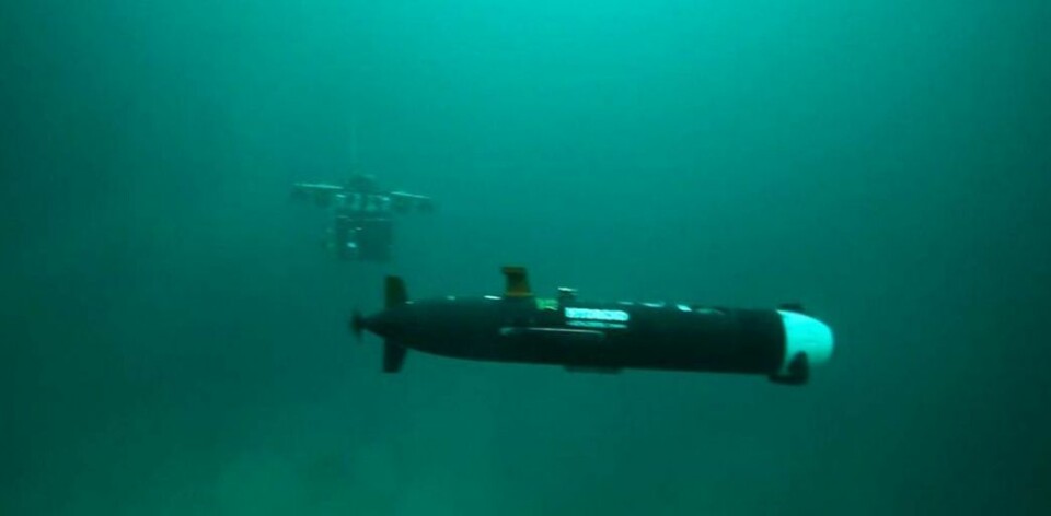 En AUV i forgrunnen, langtrekkende selvgående miniubåt som kan utforske store havbunnområder. AUV står for autonomous underwater vehicle. I bakgrunnen skimtes en ROV, remotely operated vehicle. Til sammen ser de to langt og dypt. (Foto: AUR-lab, NTNU)
