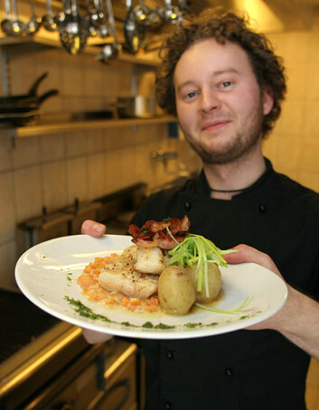"Kjøkkensjef Jørgen Nielsen med grillet tørrfisk - en rett som er populær både blant lokalbefolkning og turister." "Kjøkkensjef Jørgen Nielsen med grillet tørrfisk - en rett som er populær både blant lokalbefolkning og turister."