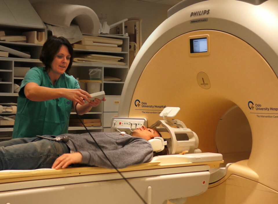 Radiograf Grethe Løvland hjelper forskning.nos journalist Per Byhring på plass i fMRI-maskinen i Intervensjonssenteret på Oslo Universitetssykehus, Rikshospitalet. (Foto: Arnfinn Christensen, forskning.no)
