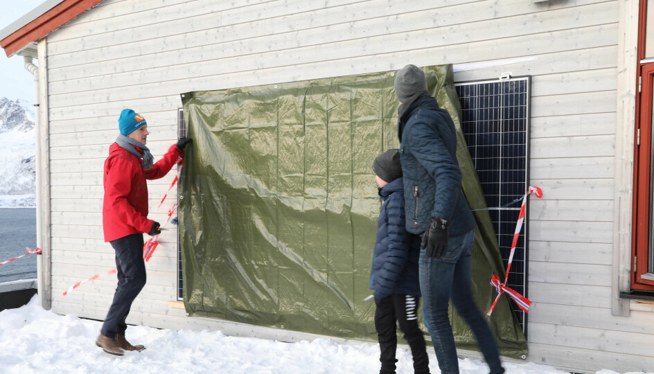 Direktør i NVE, Kjetil Lund og en elev fra Husøy skole avdekker solcellepaneler som skal forsyne skolen med energi. Avdukingen markerte åpningen av prosjektet Smart Senja.