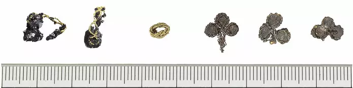 De seks edelmetallgjenstandene funnet i grava. Helt til venstre er de to gullringene med hver sin perle, så den lille gullperla og de tre sølvplatene med forgylte tråder til høyre.