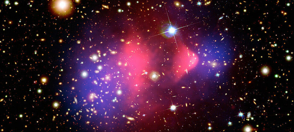 Det røde området i midten viser røntgenstråling fra to kolliderende galaksehoper, fotografert med romteleskopet Chandra. Vanlig materie ble bremset opp i kollisjonen (rødt), mens den mørke materien fortsatte tvers gjennom, upåvirket (blått). Den mørke materien er tegnet inn i fotografiet, da den ikke kunne påvises direkte, bare måles ut fra hvordan tyngdekreftene deres avbøyde lysstråler fra galaksene. NASA/CXC/M. Weiss