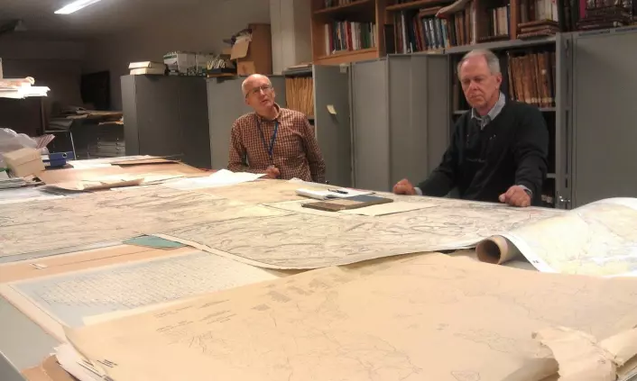 Johnny Andersen (til venstre) og Ulf Hansen jobber på Statens kartverk. Begge har jobbet med kartoppmåling og feltarbeid, på samme måte som de danske offiserene noen hundreår før. Her i arkivet foran gamle kart fra hele Kartverkets historie - som startet i 1773, (Foto: Nina Kristiansen)
