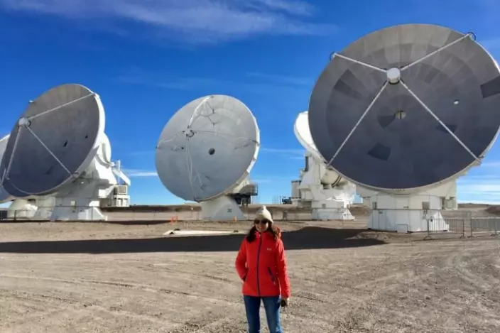 Claudia Cicone and the antennas of the Atacama Large Millimeter/sub-millimeter Array (ALMA). Their diameter is 12 metre, while AtLAST is designed to be four times bigger.