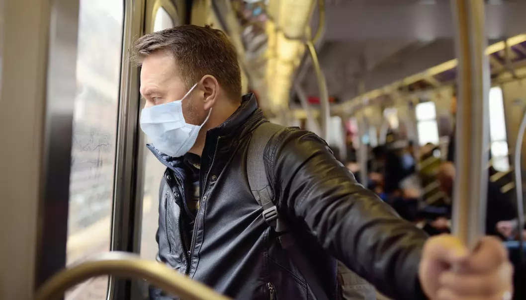 En person beskytter seg med maske på T-banen i New York under koronavirusutbruddet.
