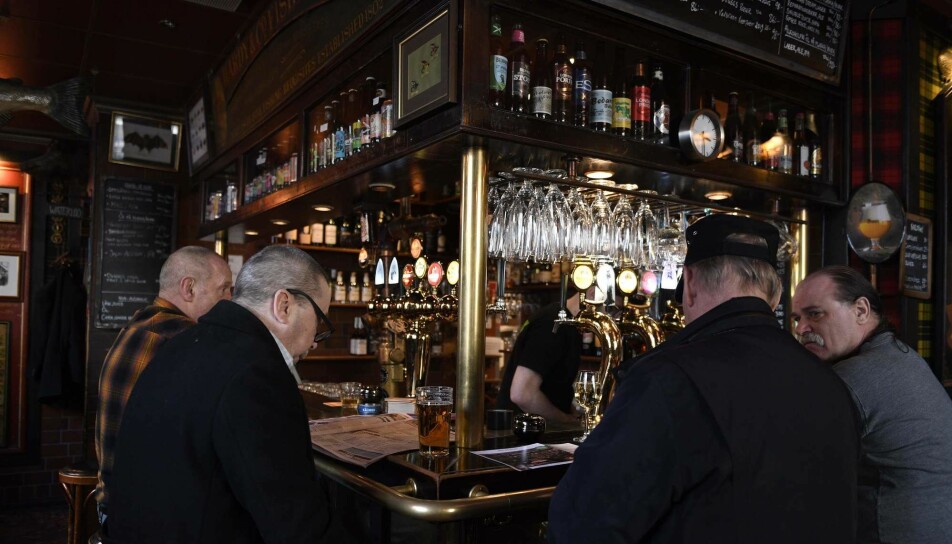 Menn drikker øl på bar i Stockholm 23. mars i år. Mens Oslos ølkraner var stengt, har restauranter og barer holdt åpent i Sverige til tross for koronakrisen.