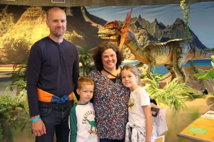 Familien Griffiths Sandaune har tatt truren til vitenskapssenteret i Sarpsborg i ferien. I bakgrunnen er en modell av Dilophosaurus.