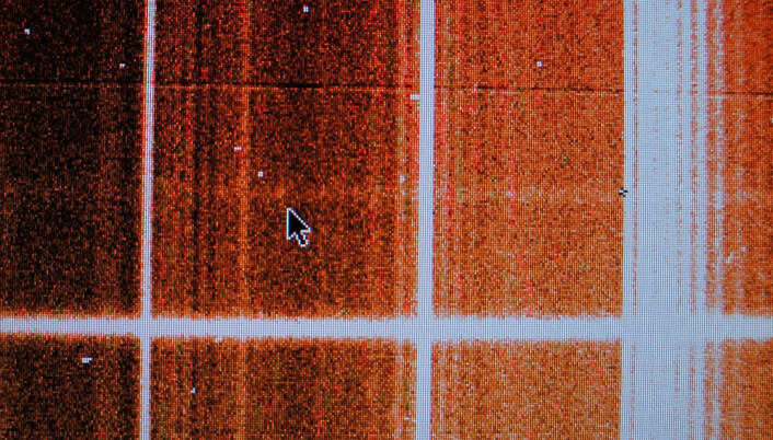 Den nesten usynlige lysflekken ved kursorpila er det astronomen bak forsøket er ute etter. Den kommer fra lysspekteret til en fjern galaksehop. (Foto: Arnfinn Christensen)