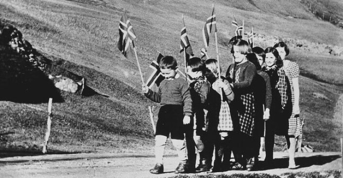 Tyske myndigheter forbød feiringen av 17. mai og å vise det norske flagget. Her et lite barnetog i en bygd i Nord-Norge, der ungene trosser forbudet. Det gikk mange slik tog under krigen. (Foto: Scanpix) Tyske myndigheter forbød feiringen av 17. mai og å vise det norske flagget. Her et lite barnetog i en bygd i Nord-Norge, der ungene trosser forbudet. Det gikk mange slik tog under krigen. (Foto: Scanpix)