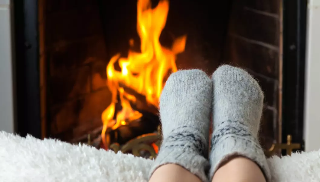 Children's feet in warm woolen socks heated in the fire in the fireplace