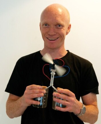 Ole Martin Løvvik demonstrerer termoelektrisitet med ett glass kaldt og ett glass varmt vann. Den nye teknologien utnytter temperaturforskjellen og gir energi til en hurtig roterende vifte. (Foto: Yngve Vogt) Ole Martin Løvvik demonstrerer termoelektrisitet med ett glass kaldt og ett glass varmt vann. Den nye teknologien utnytter temperaturforskjellen og gir energi til en hurtig roterende vifte. (Foto: Yngve Vogt)