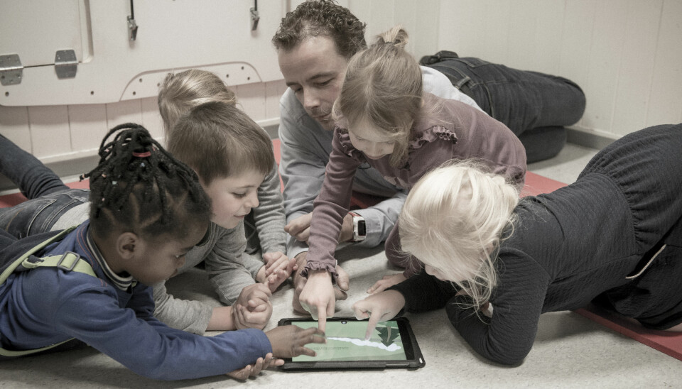 The interactive possibilities pull the children in one direction, while the kindergarten teacher works to maintain the children's attention and have discussions with them.