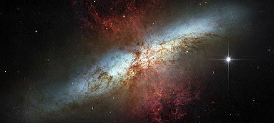 "Dette bildet av M82 er en mosaikk av fotografier tatt i synlig lys av romteleskopet Hubble. De hete hydrogenstormene står ut fra kjernen i rødt. Foto: ESA"