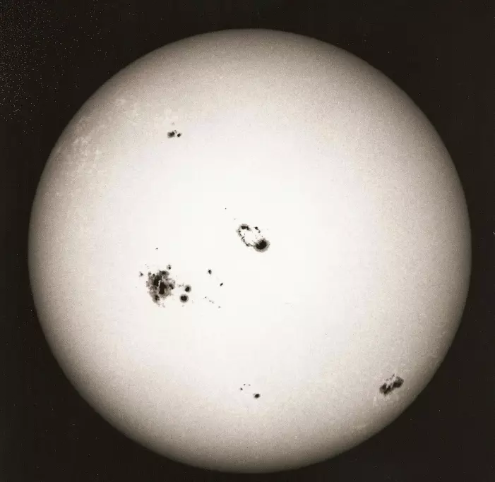 Sola sett gjennom filter, slik at solflekkene blir tydelige. Her er flere flekker synlige i 2003, under solsyklus 23.