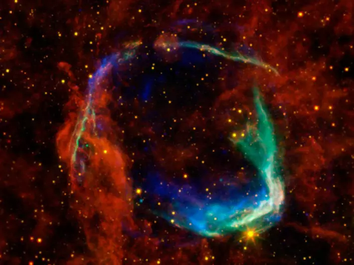 Restene av supernovaen fra 185 e.Kr, i en montasje av fotografier fra fire forskjellige romteleskop: De gule og røde delene er fra NASAs WISE-teleskop, og viser støv som stråler i infrarøde varmestråler. De blå og grønne delene viser røntgenstråler observert med det europeiske XMM-Newton-observatoriet og NASAs Chandra-observatorium. (Foto: ESA/NASA)