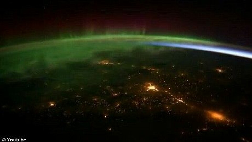 Kameraene har fanget opp grønt, dansende nordlys. Lys fra evigvåkne storbyer har også blitt med. (Foto: NASA/© Youtube)