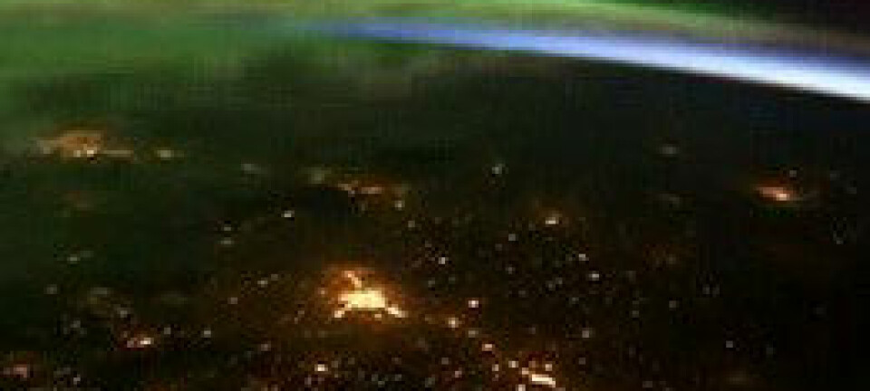 Kameraene har fanget opp grønt, dansende nordlys. Lys fra evigvåkne storbyer har også blitt med. NASA/© Youtube