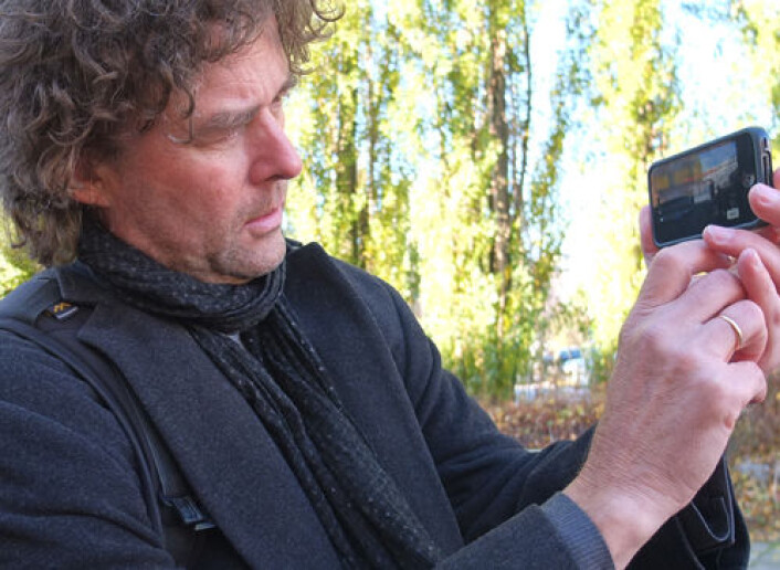 Professor Gunnar Liestøl demonstrerer hvordan du kan ta bilder av den virtuelle og den virkelige verden samtidig. (Foto: Norunn K. Torheim) Professor Gunnar Liestøl demonstrerer hvordan du kan ta bilder av den virtuelle og den virkelige verden samtidig. (Foto: Norunn K. Torheim)