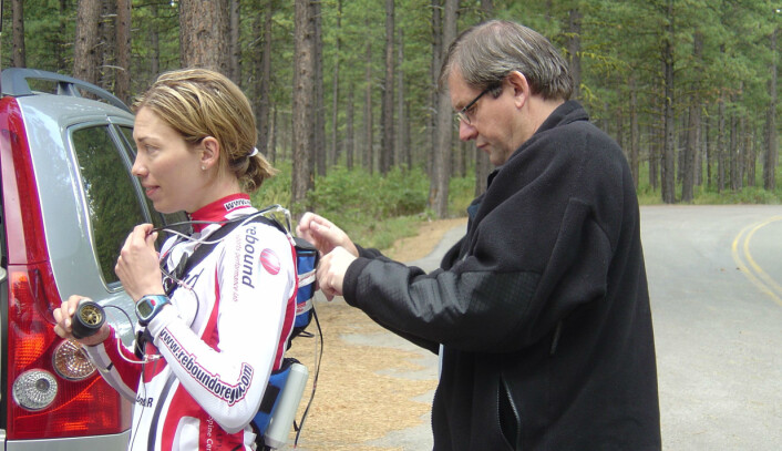 Her monterer professor Jan Helgerud bærbart utstyr for måling av oksygenopptak. Kvinnen på bildet er Beckie Scott, olympisk mester i langrenn fra Canada. Det som skulle testes her var maksimalt oksygenopptak på rulleski. (Foto: Privat) Her monterer professor Jan Helgerud bærbart utstyr for måling av oksygenopptak. Kvinnen på bildet er Beckie Scott, olympisk mester i langrenn fra Canada. Det som skulle testes her var maksimalt oksygenopptak på rulleski. (Foto: Privat)