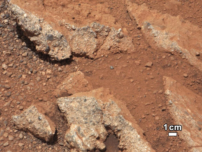Disse småsteinene stikker ut av støvet som ellers dekker mye av overflaten til Mars. Dette ser ut som en samling småsteiner som er kittet sammen til et konglomerat. Slike konglomerat av rundslipte steiner trenger rennende vann for å oppstå. (Foto: NASA/JPL) Disse småsteinene stikker ut av støvet som ellers dekker mye av overflaten til Mars. Dette ser ut som en samling småsteiner som er kittet sammen til et konglomerat. Slike konglomerat av rundslipte steiner trenger rennende vann for å oppstå. (Foto: NASA/JPL)