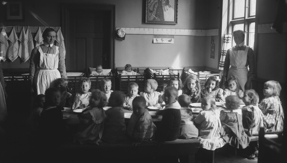 Slik satt de minste barna på rekke og rad rundt formiddagsbordet i barnekrybbene i 1908. Her fra Frelsesarmeen barnekrybbe i Oslo.
