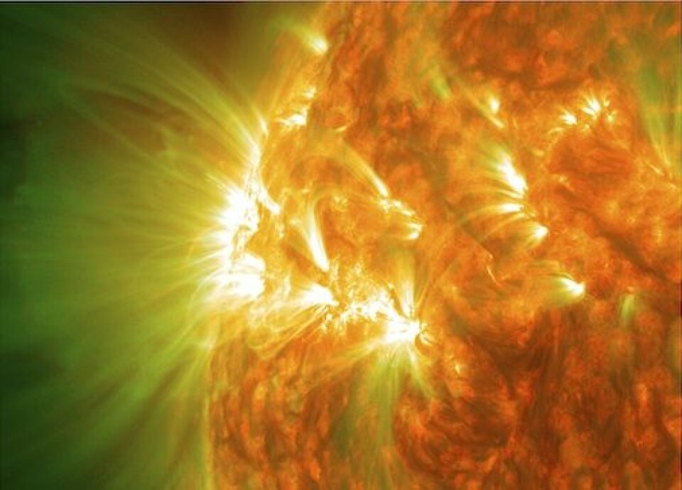 Et aktivt område på solen, med gassløkker. Dette bildet er egentlig en kombinasjon av bilder tatt med ulike filtre og kan dermed vise gass ved forskjellige temperaturer. Gass som er rundt 1 million grader er på bildet vist som grønt, mens kjøligere gass, rundt 80 000 grader, er rødt. Det hvite er en kombinasjon av de to. (Foto: Solar Dynamics Observatory)