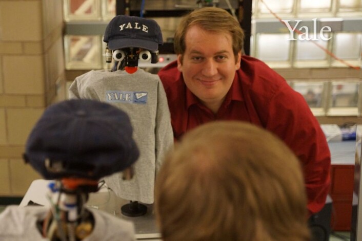 En av "pappaene" til NICO, Justin Hart poserer med den universitetspatriotisk kledde kjendisroboten. (Foto: Dan Leyzberg/ Yale University) En av "pappaene" til NICO, Justin Hart poserer med den universitetspatriotisk kledde kjendisroboten. (Foto: Dan Leyzberg/ Yale University)
