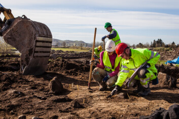 Prosjektleder Even Bjørdal (t.h) ser etter spor fra fortidens mennesker sammen med feltassisten Eirin Husby Frey. I bakgrunnen følger Sean Denham med på hva gravemaskinen avdekker. (Foto: Morten Berentsen) Prosjektleder Even Bjørdal (t.h) ser etter spor fra fortidens mennesker sammen med feltassisten Eirin Husby Frey. I bakgrunnen følger Sean Denham med på hva gravemaskinen avdekker. (Foto: Morten Berentsen)