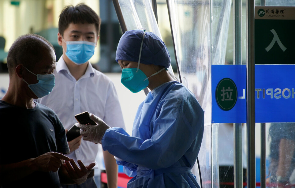En sykepleier i Wuhan i Kina bruker smarttelefon på jobb. Helsepersonell i Kina har omfavnet WeChat for å kommunisere raskt på tvers av sykehus og landegrenser.