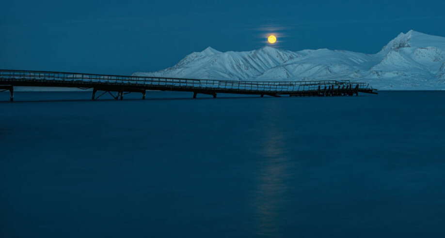 Mørketid med fullmåne i blåtimen, her over «gammelkaia» ved Ny-Ålesund. Kaia er i ferd med å kollapse under påvirkning fra naturkreftene, og ferdsel på den er forbudt.