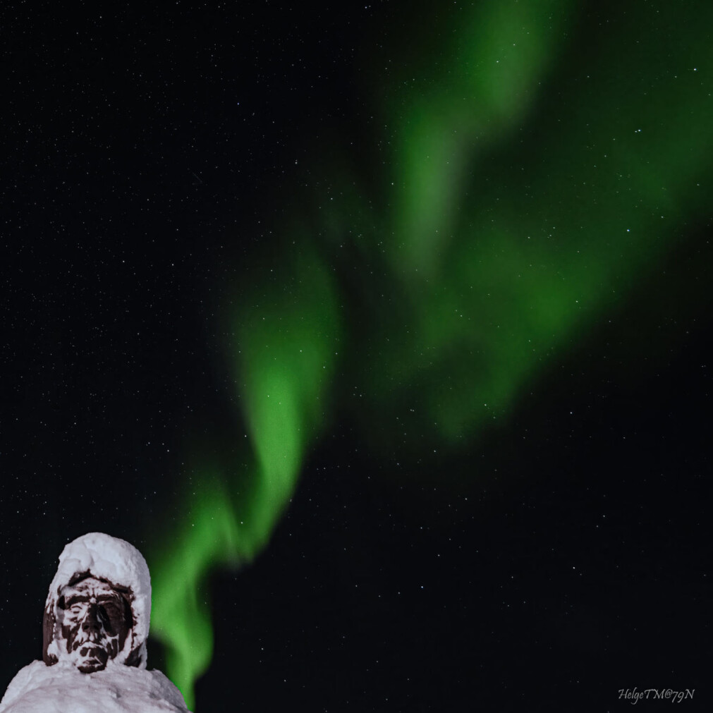 Statuen av Roald Amundsen i Ny-Ålesund lyser opp under nordlyset. Bildet ble tatt en snørik dag i oktober. Statuen av Roald Amundsen i Ny-Ålesund lyser opp under nordlyset. Bildet ble tatt en snørik dag i oktober.