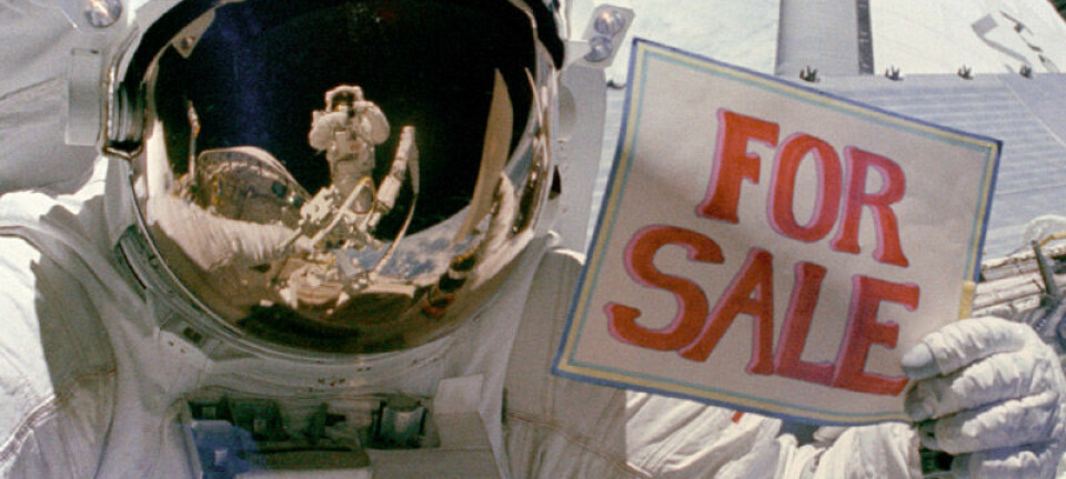 Astronauten Dale A. Gardner holder opp skilt etter å ha hentet inn to kommersielle satellitter, Palapa B-2 og Westar 6, for reparasjon 14. november 1984. NASA