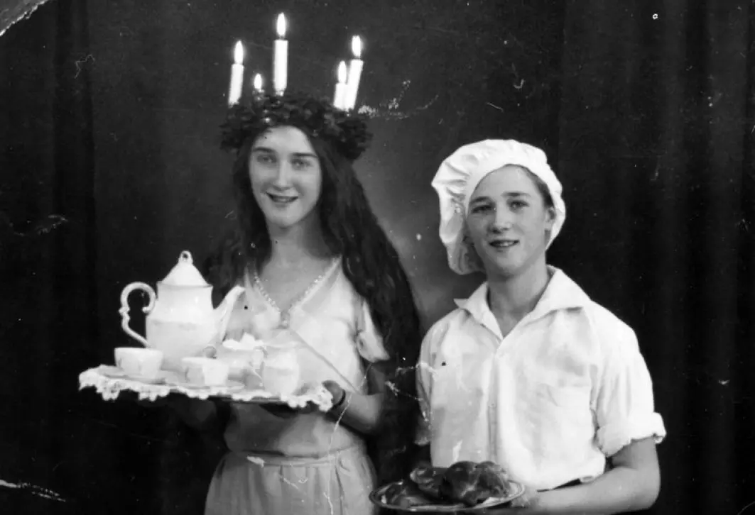 En Lucia og en bakergutt serverer kaffe og lussekatter i et svensk hjem i 1933.