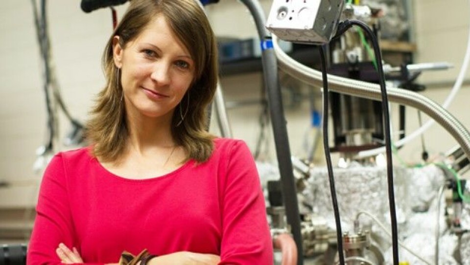 Forsker Charlotte Sanders i teamet som står bak verdens minste nanolaser. Bak Sanders skimter vi en av maskinene som er brukt for å lage laseren. (Foto: Alex Wang, University of Texas)