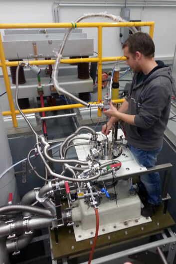 Dr. Joseph Law ved laboratoriet i Dresden setter inn en prøve i høyfeltmagneten. Prøven er kjølt ned i flytende helium, mens kobberspolen på magneten er dyppet i flytende nitrogen. Foto: NGU Dr. Joseph Law ved laboratoriet i Dresden setter inn en prøve i høyfeltmagneten. Prøven er kjølt ned i flytende helium, mens kobberspolen på magneten er dyppet i flytende nitrogen. Foto: NGU