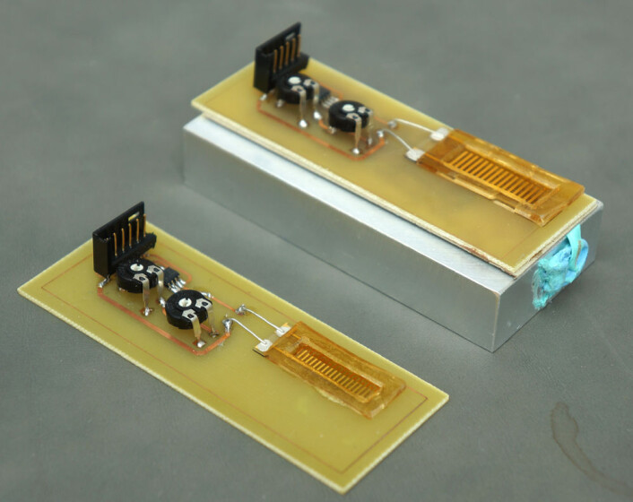 To prototyper av energihøsteren basert på en strømledende dråpe som glir over elektroder, utviklet ved Institutt for mikro- og nanoteknologi ved Høgskolen i Vestfold. (Foto: Arnfinn Christensen) To prototyper av energihøsteren basert på en strømledende dråpe som glir over elektroder, utviklet ved Institutt for mikro- og nanoteknologi ved Høgskolen i Vestfold. (Foto: Arnfinn Christensen)