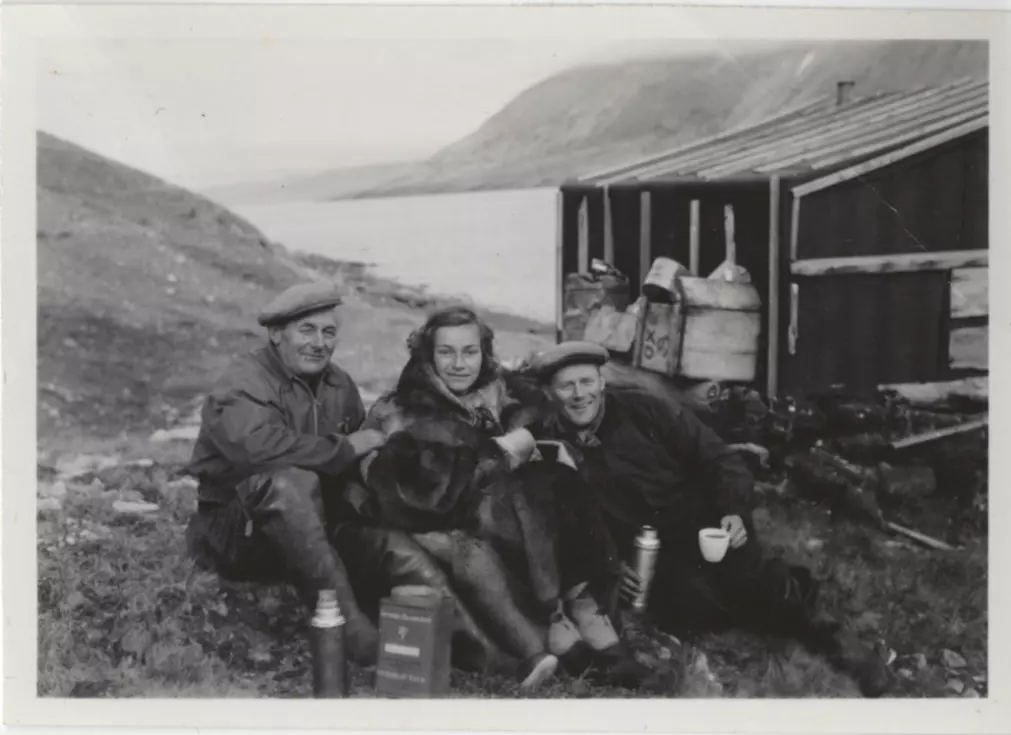 Brit Hofseth sammen med fangstmennene Henry Rudi (t.v.) og Schjølberg Nilsen utenfor en fangsthytte på Revet på Grønland.