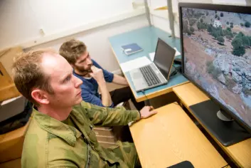 Oberstløytnant Geir Karlsen ser etter utplasserte kamuflerte mannekenger i varierende terreng i en test utviklet av FFI. I bakgrunnen forsker Gorm Krogh Selj. (Foto: FFI)