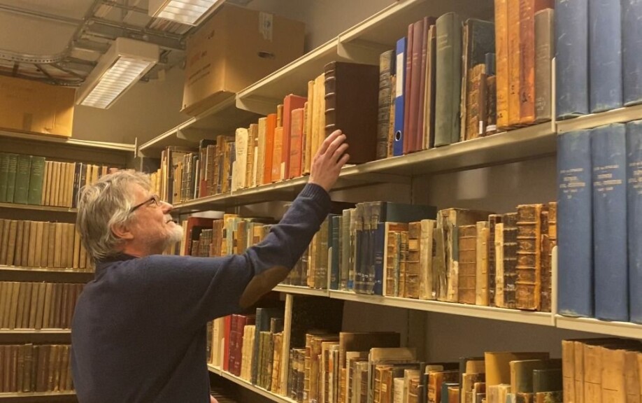 Polarbibliotekar Ivar Stokkeland oppbevarer boka Historien om de nordiske folk bak lås og slå.