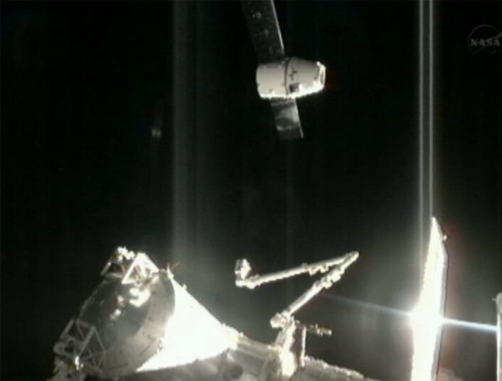 Romkapselen Dragon ankommer Den internasjonale romstasjonen 10.oktober 2012 med den første ordinære lasten. Nederst sees robotarmen Canadarm2, som skal strekkes ut for å fange inn Dragon. (Foto: NASA) Romkapselen Dragon ankommer Den internasjonale romstasjonen 10.oktober 2012 med den første ordinære lasten. Nederst sees robotarmen Canadarm2, som skal strekkes ut for å fange inn Dragon. (Foto: NASA)