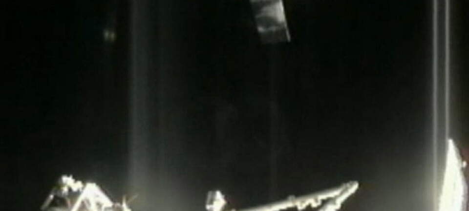 Romkapselen Dragon ankommer romstasjonen 10. oktober 2012. Nederst sees robotarmen Canadarm2, som skal strekkes ut for å fange inn Dragon. NASA