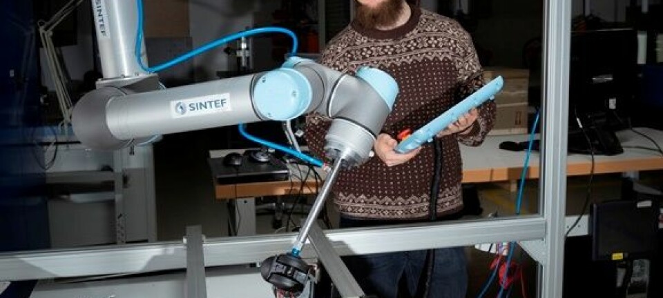 Forsker Sigurd Albrektsen med roboten i laben. Åse Dragland/Sintef