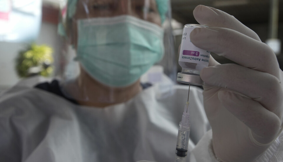En helsearbeider fyller en sprøyte med koronavaksinen til AstraZeneca på Bali i Indonesia mandag. En ny omfattende studie bekrefter at vaksinen er både effektiv og ufarlig.
