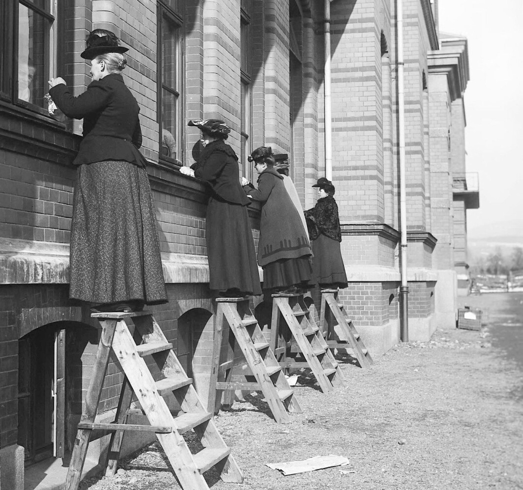 Bildet er fra 1905 og tatt under en difteriepidemi på Ullevål sykehus. Infeksjonssykdommer florerte, særlig der folk bodde trangt. Disse kvinnene besøker slektninger som er innlagt på sykehuset, men må stå utenfor for å unngå å bli smittet. Bildet er fra 1905 og tatt under en difteriepidemi på Ullevål sykehus. Infeksjonssykdommer florerte, særlig der folk bodde trangt. Disse kvinnene besøker slektninger som er innlagt på sykehuset, men må stå utenfor for å unngå å bli smittet.