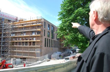 Marius Nygaard teller etasjer og viser vindusløsninger på et av nybyggene ved Vulkan i Oslo. Ting som her er gjort i teglstein og stål, kunne like gjerne vært laget av tre, mener han. (Foto: Hanne Østli Jakobsen) Marius Nygaard teller etasjer og viser vindusløsninger på et av nybyggene ved Vulkan i Oslo. Ting som her er gjort i teglstein og stål, kunne like gjerne vært laget av tre, mener han. (Foto: Hanne Østli Jakobsen)