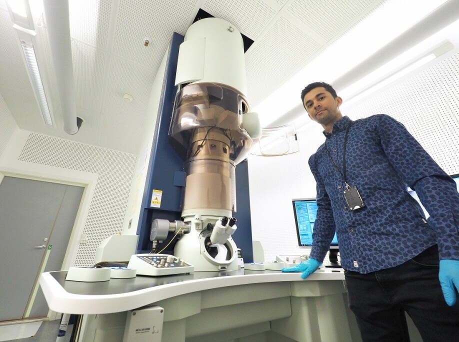 Adrian Lervik med det avanserte elektronmikroskopet som gjorde det mulig å få svar.