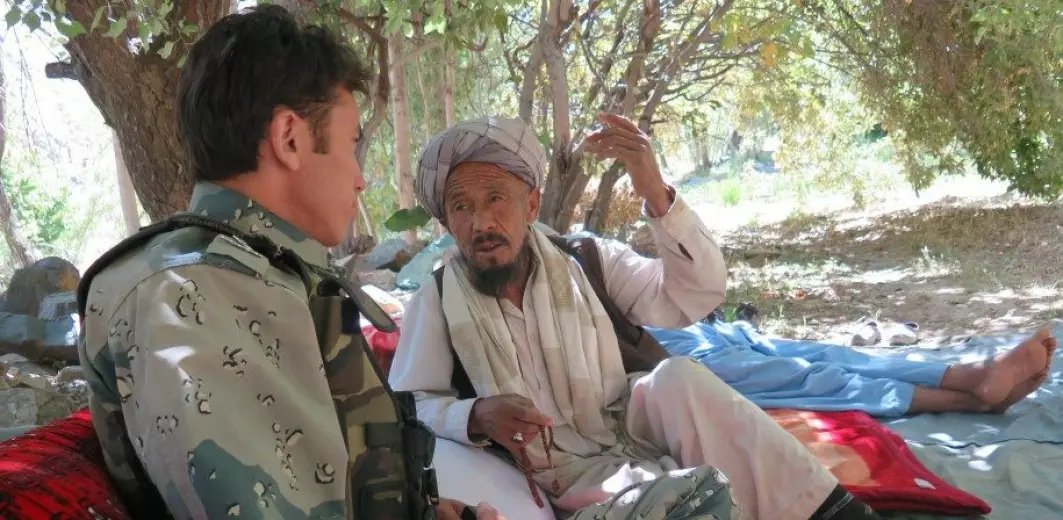 A police officer chatting with an elder who was a member of a group gathered for conflict resolution in Daikundi Province, Afghanistan as part of the Ashterlay peace process.